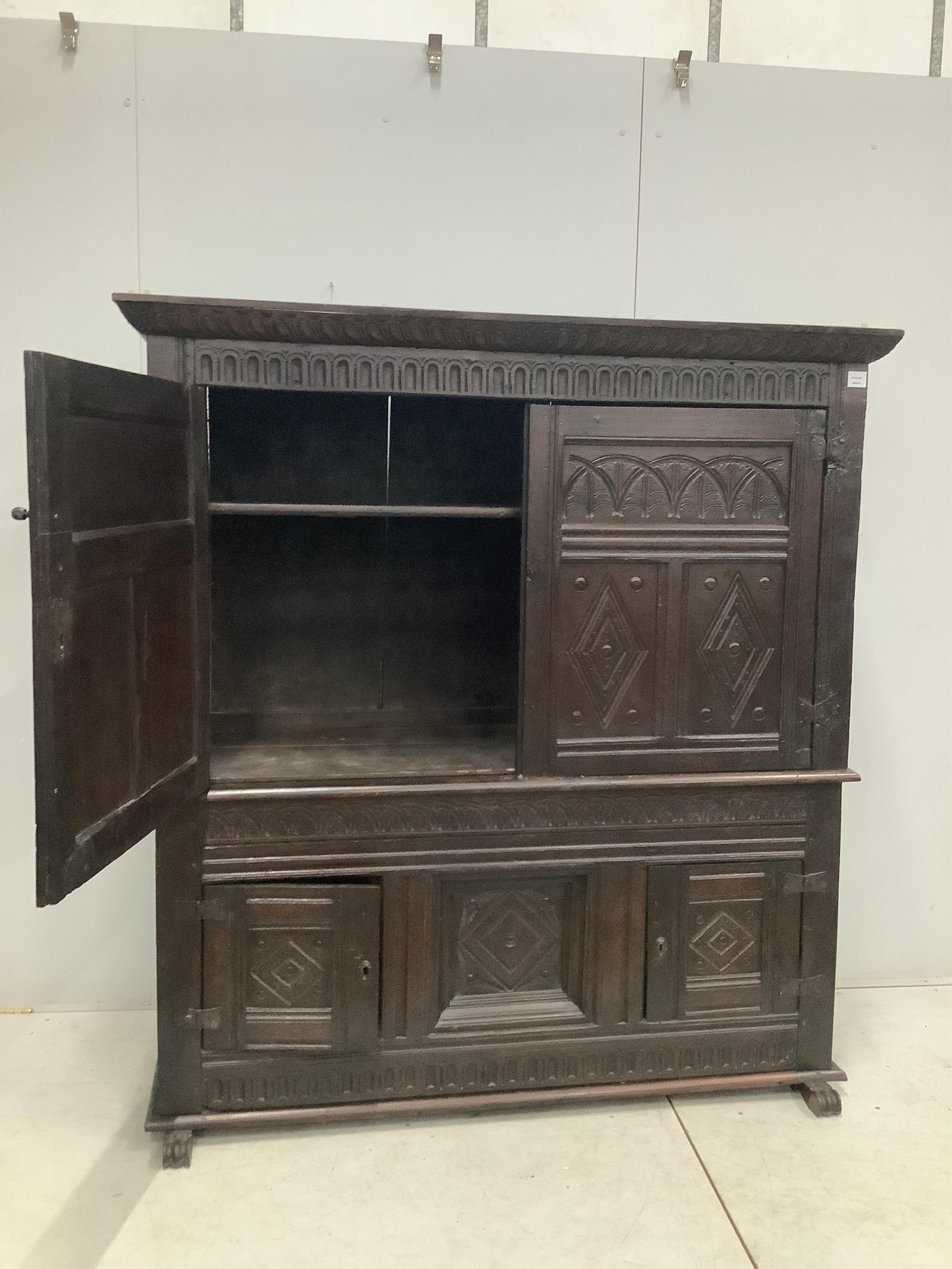 A late 17th century Continental carved oak two section cupboard, width 166cm, depth 57cm, height 167cm. Condition - fair